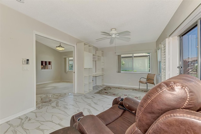 living room featuring a textured ceiling, ceiling fan, and lofted ceiling