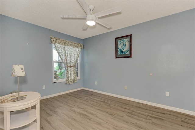 unfurnished room with ceiling fan, a textured ceiling, and light hardwood / wood-style flooring