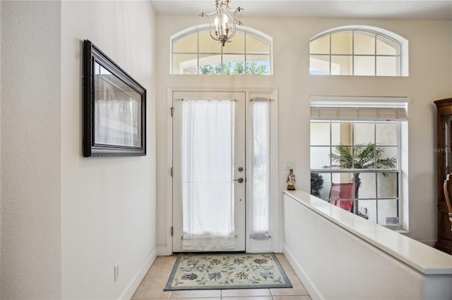 tiled entrance foyer featuring a notable chandelier