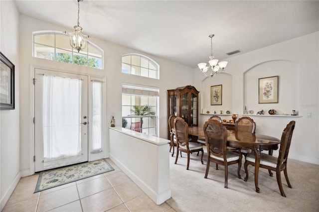 foyer featuring light tile patterned floors, a wealth of natural light, and a chandelier