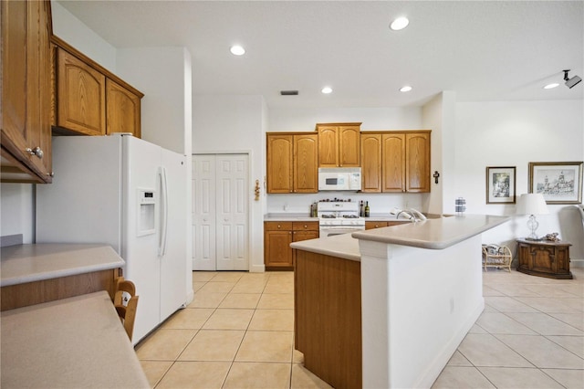 kitchen featuring kitchen peninsula, light tile patterned floors, and white appliances