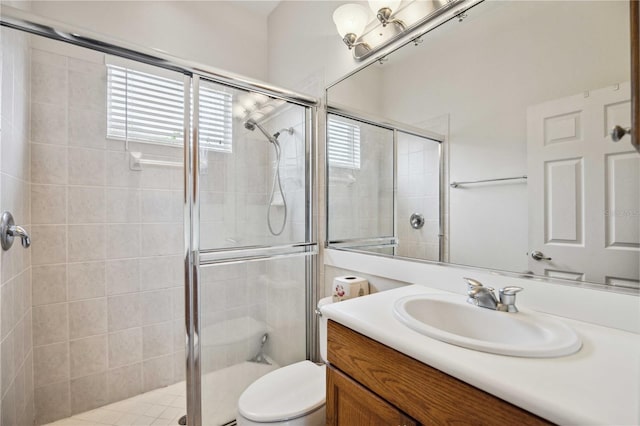 bathroom with vanity, toilet, and a shower with door