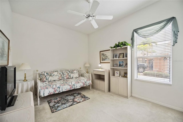 living area with light carpet and ceiling fan