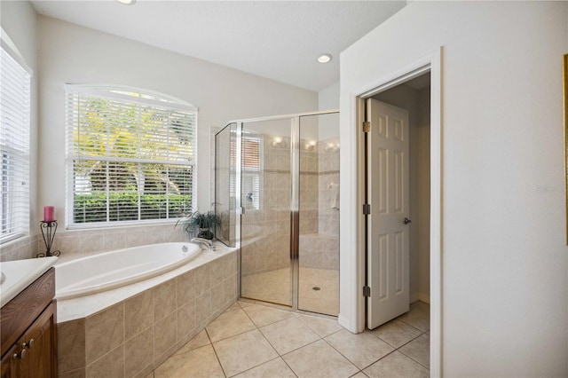 bathroom with tile patterned flooring, vanity, and shower with separate bathtub