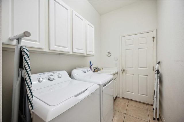 laundry room with sink, light tile patterned floors, cabinets, and independent washer and dryer