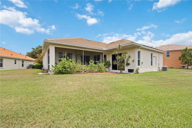 rear view of property with a lawn and central AC unit