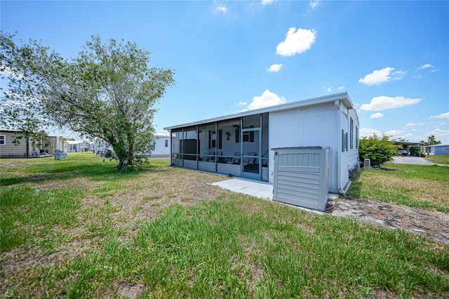 rear view of house with a sunroom and a yard