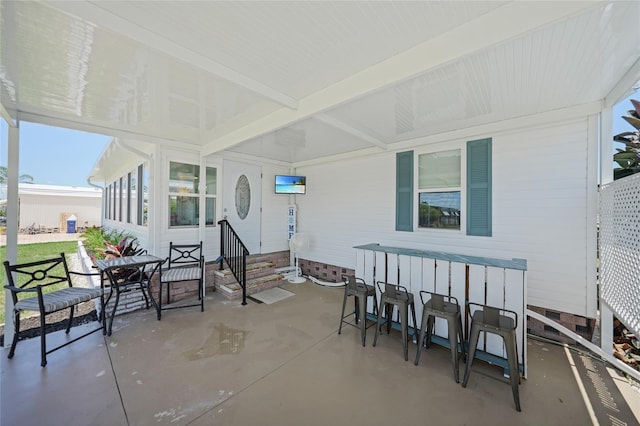 sunroom / solarium featuring beam ceiling