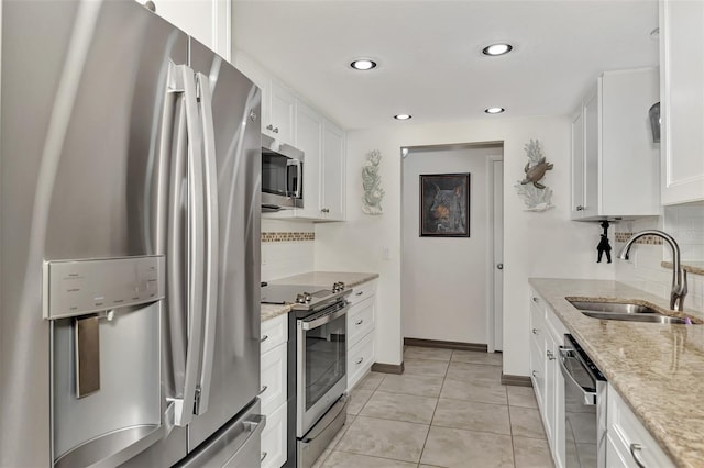 kitchen featuring light stone countertops, sink, white cabinets, and stainless steel appliances