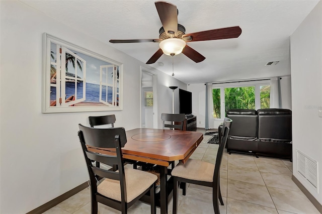 dining room featuring ceiling fan, light tile patterned flooring, and a textured ceiling