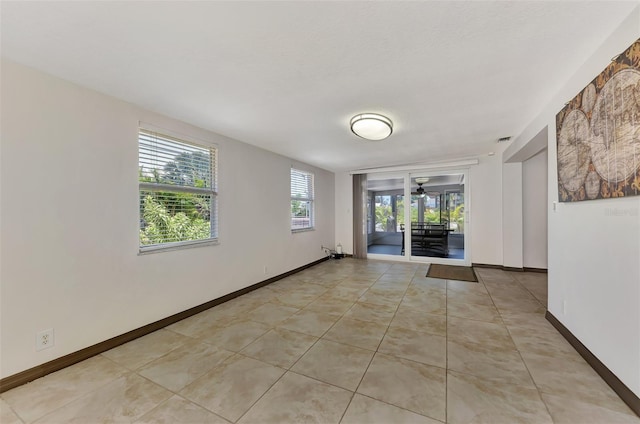 tiled empty room featuring ceiling fan