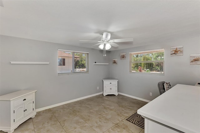 unfurnished office featuring ceiling fan and light tile patterned floors