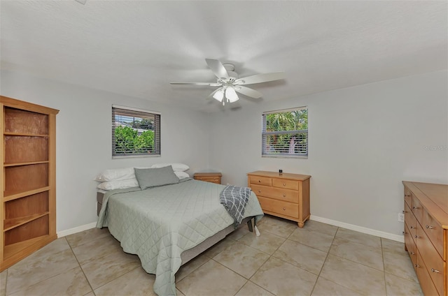 bedroom with multiple windows, ceiling fan, and light tile patterned floors