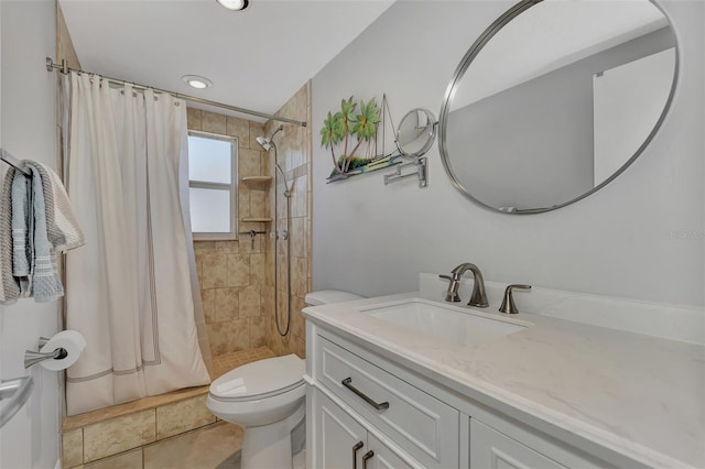 bathroom featuring tile patterned flooring, vanity, toilet, and walk in shower