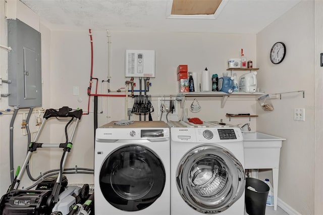 washroom featuring washing machine and clothes dryer, electric panel, and a textured ceiling