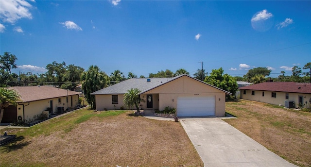 ranch-style home featuring driveway, an attached garage, cooling unit, and a front yard