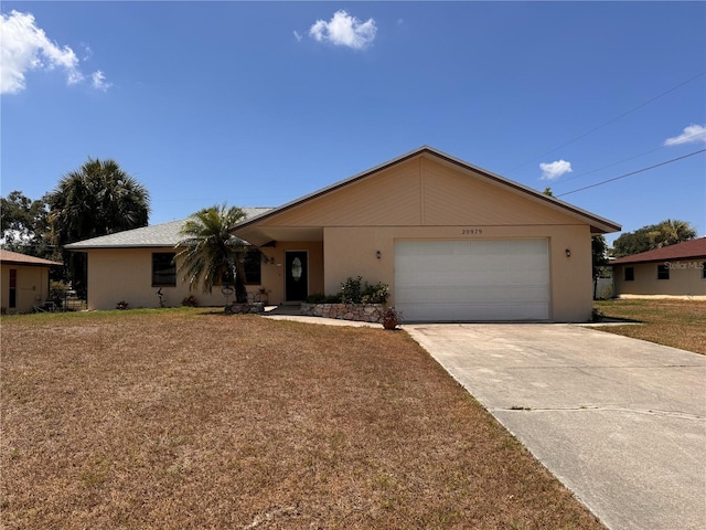 ranch-style house featuring a garage, concrete driveway, a front lawn, and stucco siding