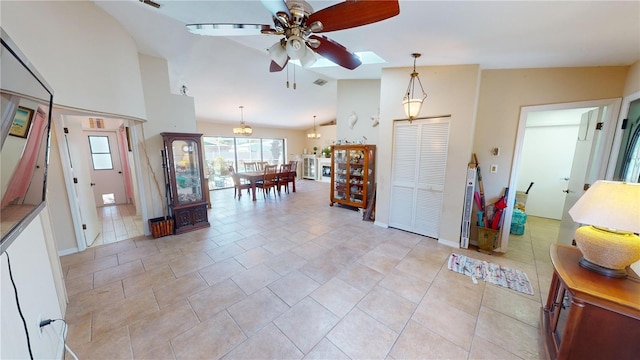 kitchen featuring pendant lighting, high vaulted ceiling, a skylight, ceiling fan, and light tile patterned flooring