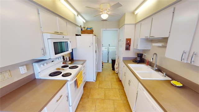 kitchen featuring washer and clothes dryer, white cabinetry, sink, and white appliances