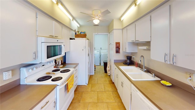 kitchen featuring washer and clothes dryer, white appliances, white cabinets, sink, and light tile patterned flooring