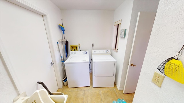 washroom with separate washer and dryer and light tile patterned flooring