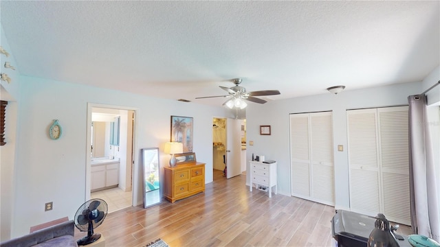 interior space featuring a textured ceiling, light hardwood / wood-style flooring, and ceiling fan