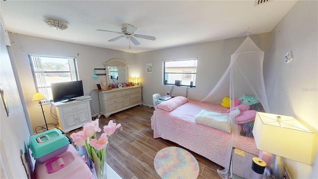 bedroom with hardwood / wood-style floors, multiple windows, and ceiling fan