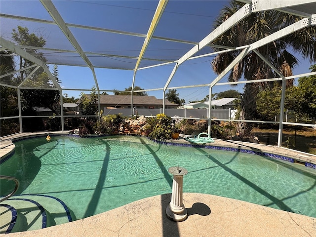 view of pool featuring glass enclosure