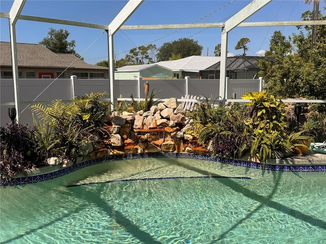 view of pool featuring glass enclosure