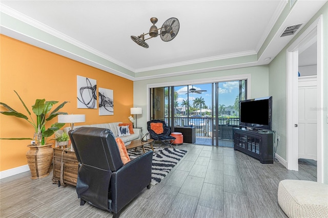 living room featuring hardwood / wood-style flooring, ceiling fan, and ornamental molding