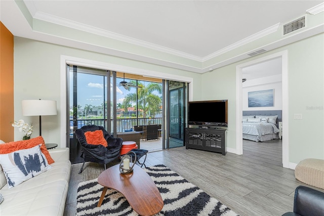 living room featuring light hardwood / wood-style floors and crown molding