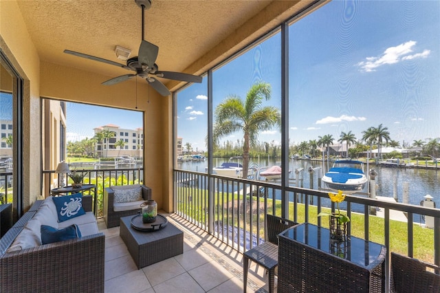 sunroom with a water view and ceiling fan