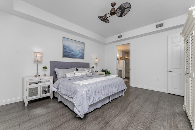 bedroom featuring dark hardwood / wood-style flooring and ensuite bath