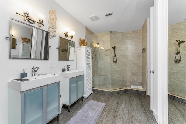 bathroom featuring tiled shower and vanity