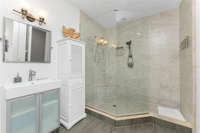 bathroom with a tile shower and vanity