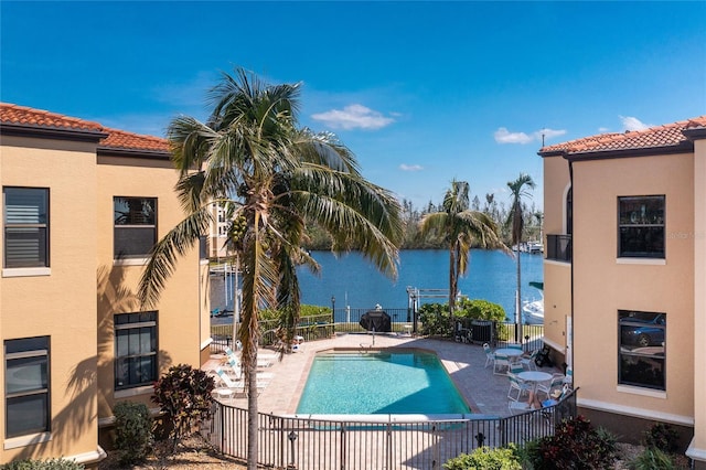 view of swimming pool with a water view and a patio