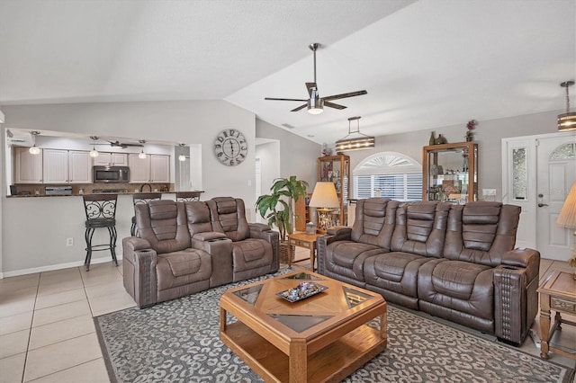 living room featuring ceiling fan, light tile patterned floors, and vaulted ceiling