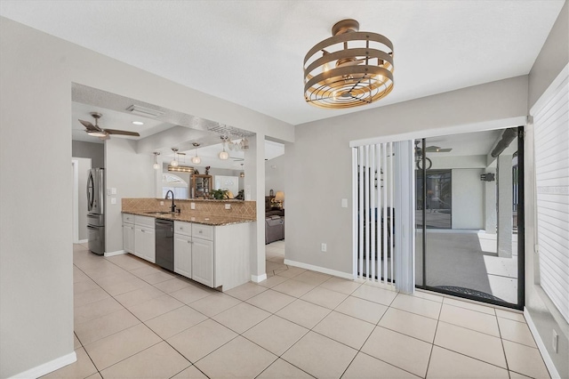 kitchen featuring sink, light tile patterned floors, black dishwasher, light stone counters, and white cabinetry