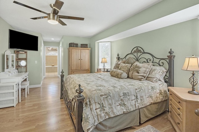 bedroom featuring light wood-type flooring, ensuite bathroom, and ceiling fan