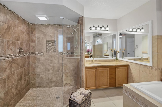 bathroom featuring tile patterned flooring, vanity, tile walls, and independent shower and bath