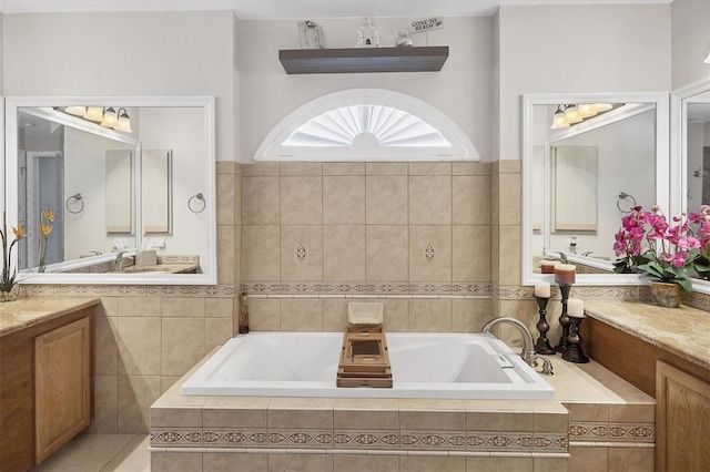 bathroom with vanity and a relaxing tiled tub