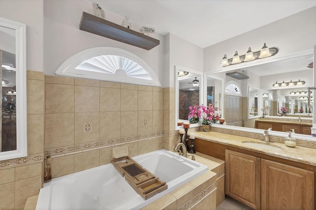 bathroom featuring vanity and a relaxing tiled tub