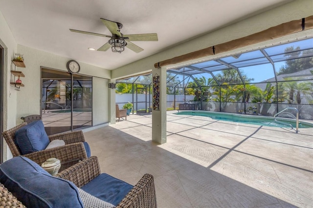 view of pool with glass enclosure, ceiling fan, and a patio area