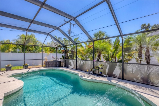 view of swimming pool featuring glass enclosure