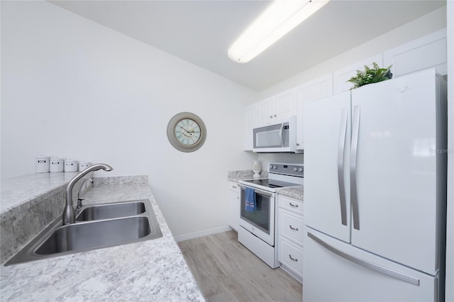 kitchen with white cabinetry, sink, light stone counters, light hardwood / wood-style flooring, and white appliances