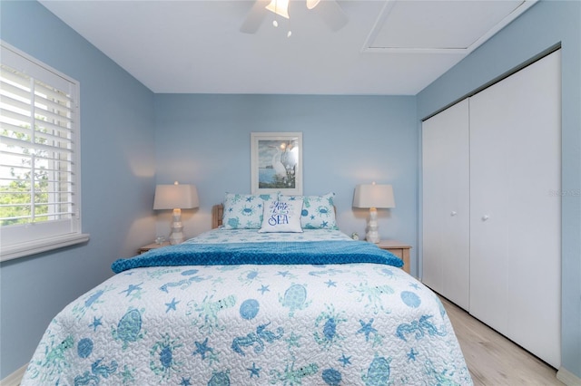 bedroom featuring a closet, light hardwood / wood-style flooring, and ceiling fan