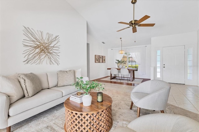 tiled living room featuring ceiling fan and lofted ceiling