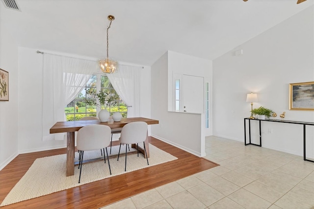 tiled dining area with a chandelier and lofted ceiling