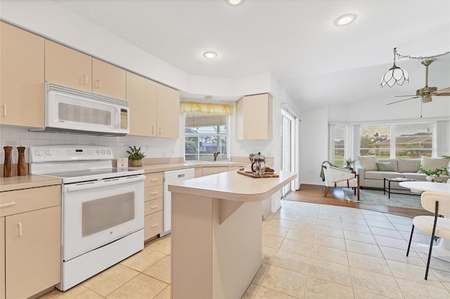 kitchen with ceiling fan, a center island, a healthy amount of sunlight, and white appliances