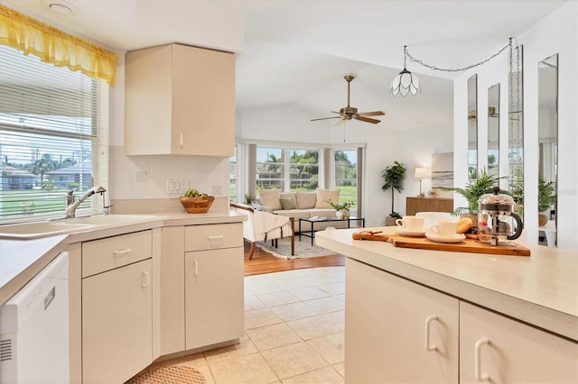 kitchen featuring ceiling fan, sink, white dishwasher, vaulted ceiling, and light tile patterned flooring